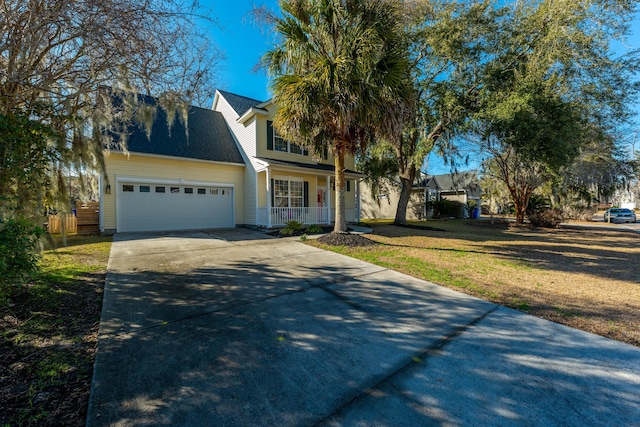 view of front of house featuring a garage, a front yard, and covered porch