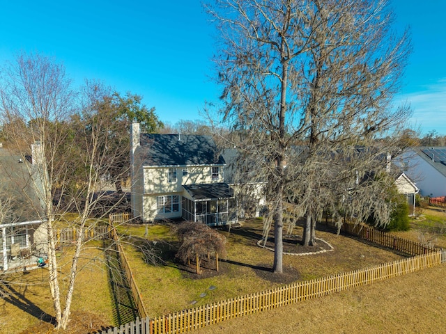 view of front facade with a front yard and a sunroom