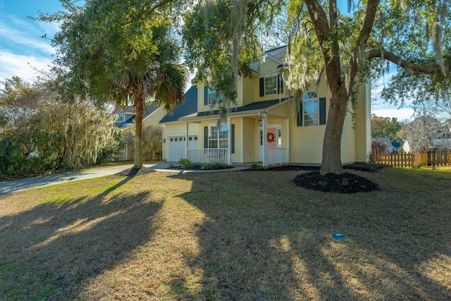 view of front of home featuring a garage, a front lawn, and covered porch