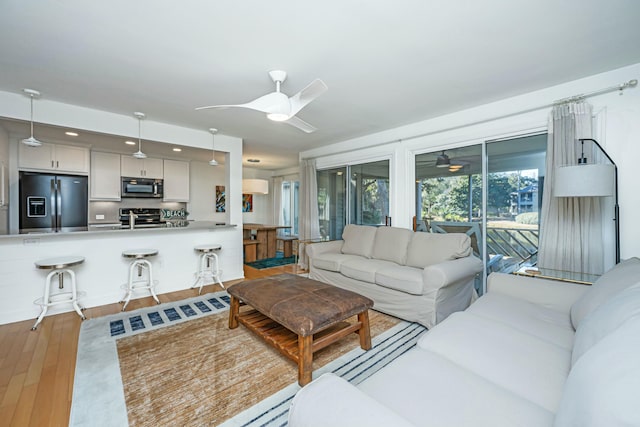 living room with ceiling fan and wood finished floors