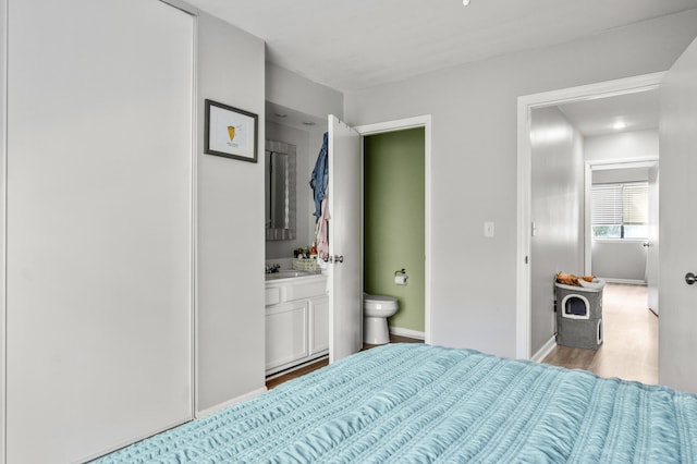 1530 Fort Johnson Rd Unit 1L, Charleston, SC 29412 - bedroom with light wood finished floors, ensuite bath, baseboards, and a sink