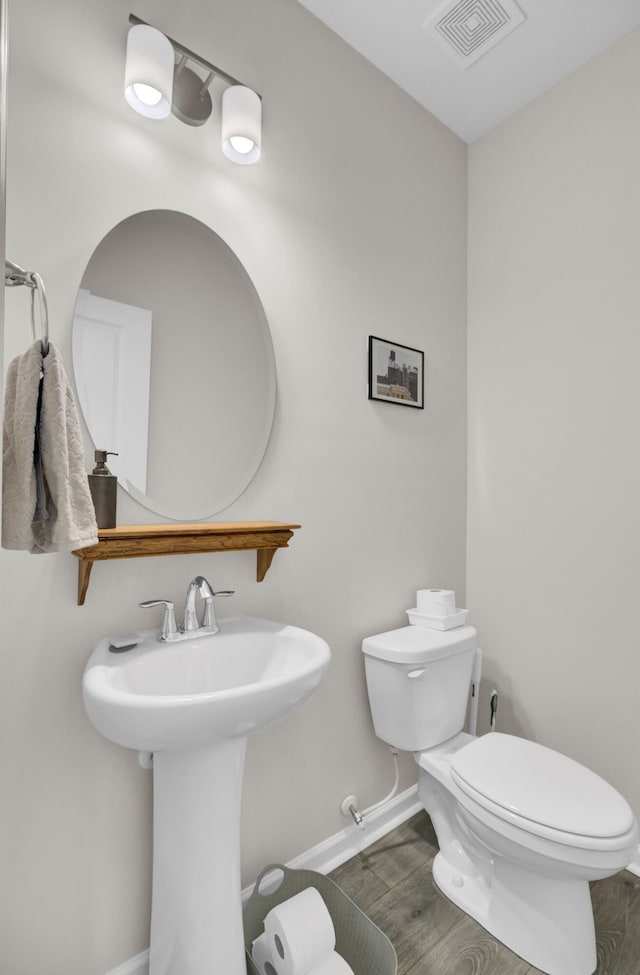 bathroom with hardwood / wood-style flooring and toilet