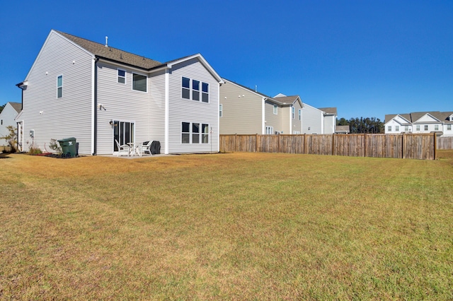 rear view of property with a yard and a patio