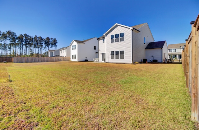 rear view of house with a lawn and central AC unit