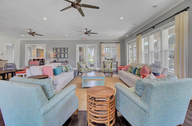 living room featuring plenty of natural light, dark wood-type flooring, french doors, and ornamental molding