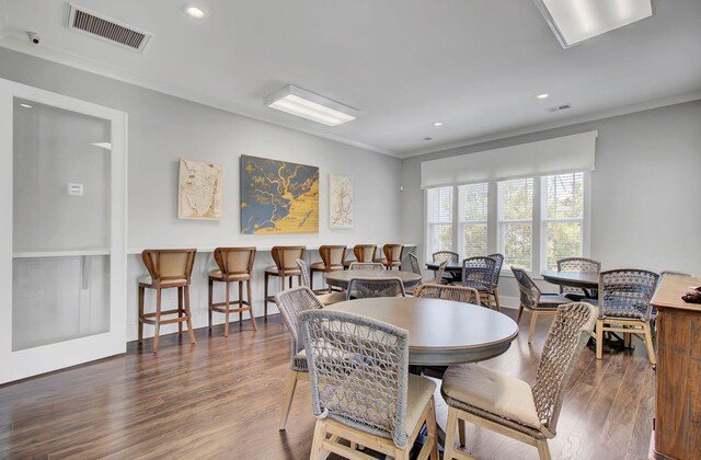 dining space with dark hardwood / wood-style flooring and ornamental molding