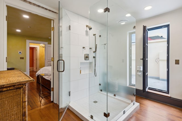 ensuite bathroom with a stall shower, ensuite bath, ornamental molding, wood finished floors, and recessed lighting