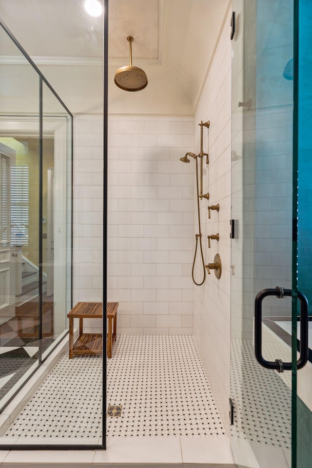 bathroom with ornamental molding and a stall shower