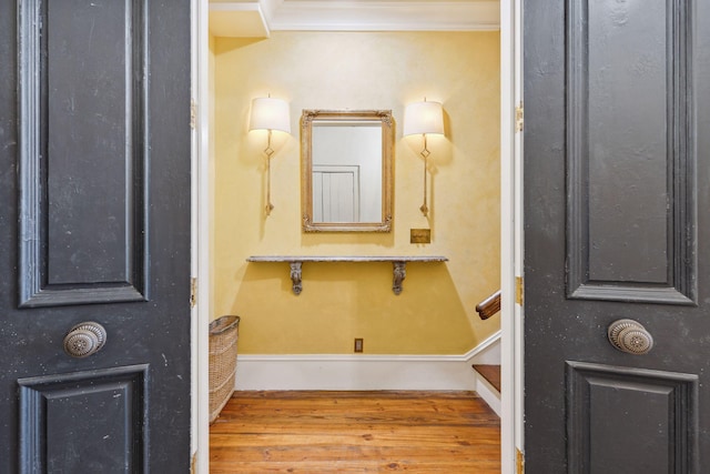 bathroom featuring baseboards, ornamental molding, and wood finished floors