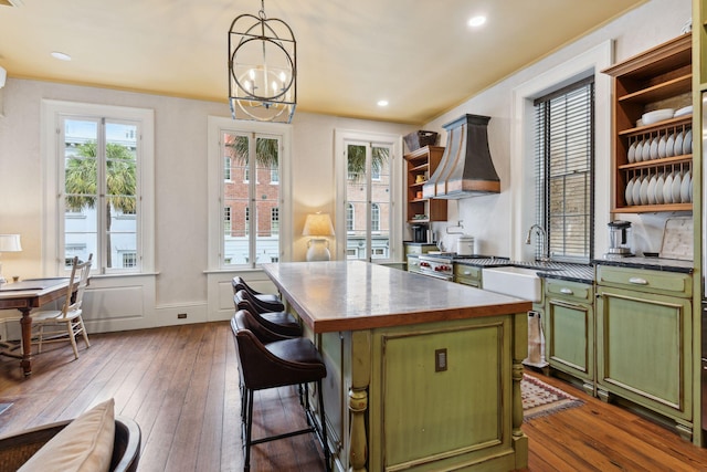 kitchen with pendant lighting, open shelves, dark countertops, a kitchen island, and green cabinetry