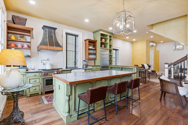 kitchen featuring designer stove, a kitchen breakfast bar, a center island, open shelves, and green cabinetry