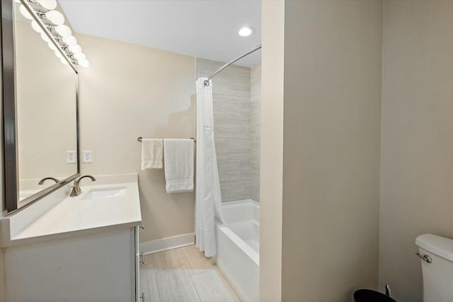 full bath featuring toilet, wood finished floors, vanity, baseboards, and shower / tub combo with curtain