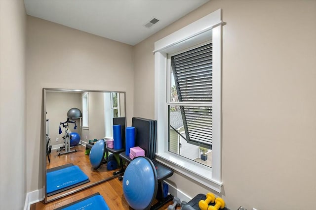 workout room with visible vents, baseboards, and wood finished floors