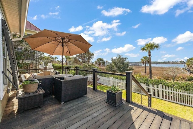 wooden terrace with a water view, a fenced backyard, and an outdoor living space