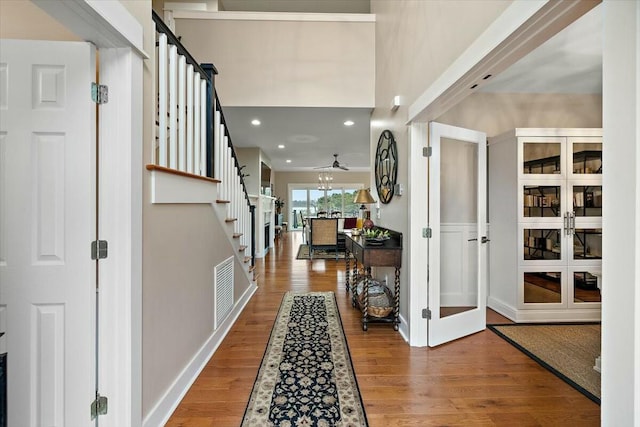 foyer entrance with stairs, recessed lighting, baseboards, and wood finished floors