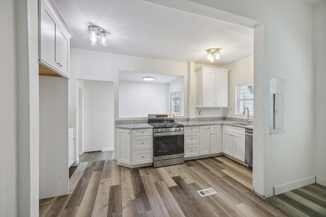 634 Rutledge Ave, Charleston, SC 29403 - kitchen with appliances with stainless steel finishes, a sink, wood finished floors, and white cabinetry