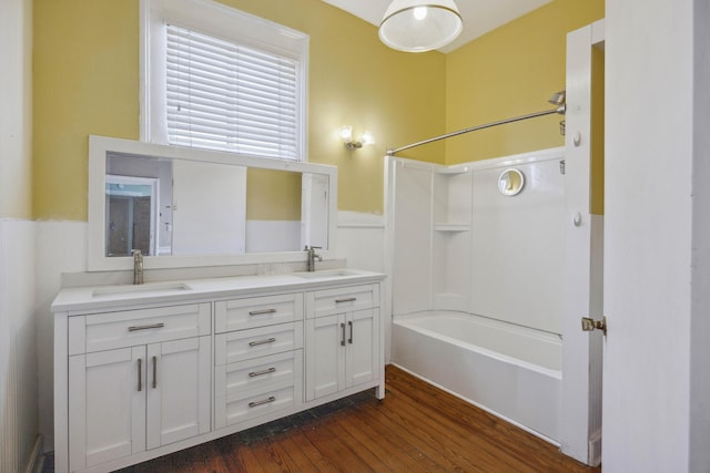 634 Rutledge Ave, Charleston, SC 29403 - bathroom featuring shower / bath combination, a wainscoted wall, wood finished floors, and double vanity