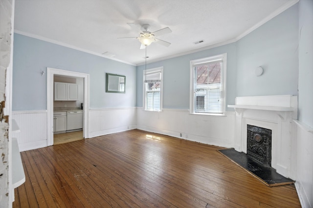 634 Rutledge Ave, Charleston, SC 29403 - unfurnished living room with ceiling fan, hardwood / wood-style floors, wainscoting, a fireplace with raised hearth, and crown molding