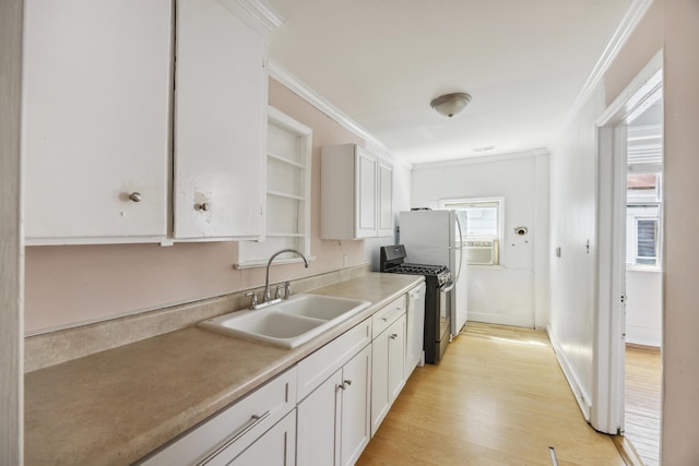 634 Rutledge Ave, Charleston, SC 29403 - kitchen with range with gas cooktop, a sink, crown molding, white cabinetry, and light wood-style floors