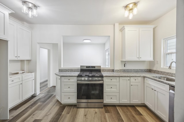634 Rutledge Ave, Charleston, SC 29403 - kitchen with appliances with stainless steel finishes, a sink, wood finished floors, and light stone counters
