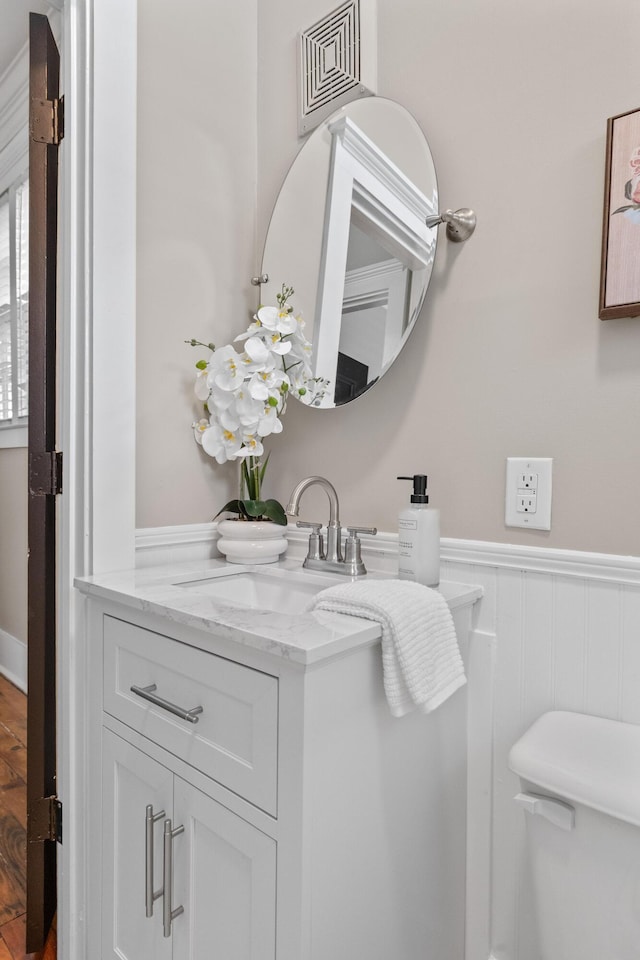 51/2 Kracke St Unit A, Charleston, SC 29403 - bathroom featuring vanity, a wainscoted wall, wood finished floors, and toilet