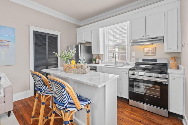 51/2 Kracke St Unit A, Charleston, SC 29403 - kitchen featuring stainless steel appliances, under cabinet range hood, a sink, ornamental molding, and a kitchen bar