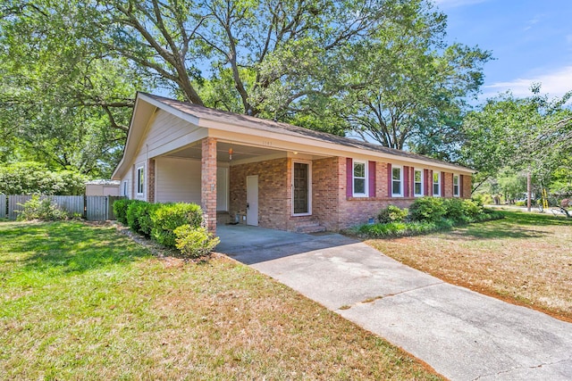 1143 Winborn Dr, Charleston, SC 29412 - view of front of house featuring fence, brick siding, an attached carport, a front yard, and concrete driveway