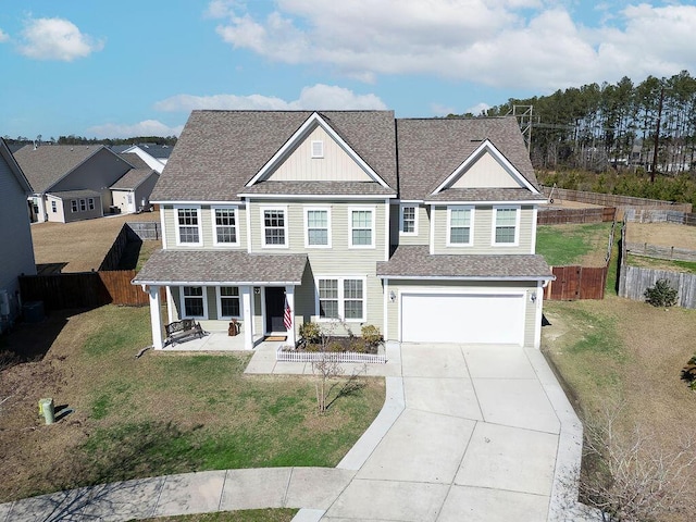 view of front facade with covered porch, a front yard, and a garage