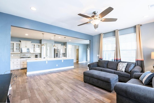 living room featuring ceiling fan and light wood-type flooring