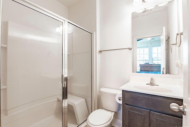 bathroom featuring toilet, vanity, and walk in shower