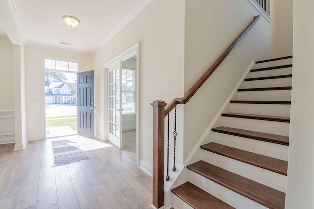 foyer featuring light hardwood / wood-style floors and crown molding