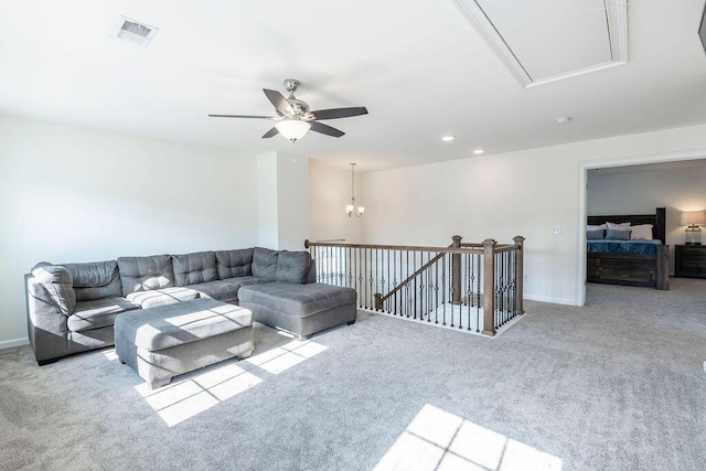 carpeted living room with ceiling fan with notable chandelier