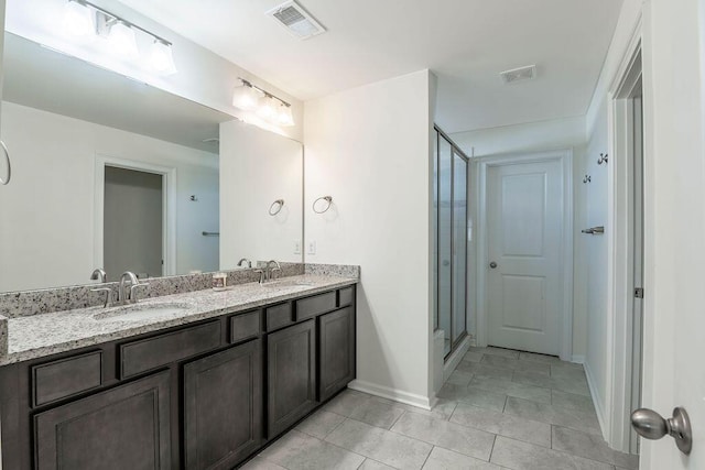 bathroom with tile patterned flooring, vanity, and walk in shower