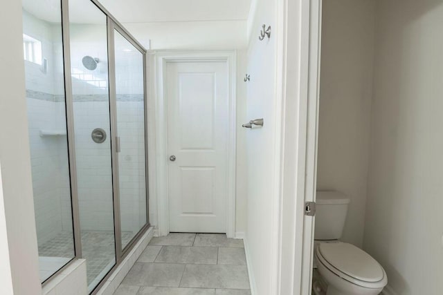 bathroom featuring tile patterned floors, an enclosed shower, and toilet