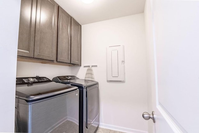 clothes washing area with electric panel, washing machine and dryer, and cabinets