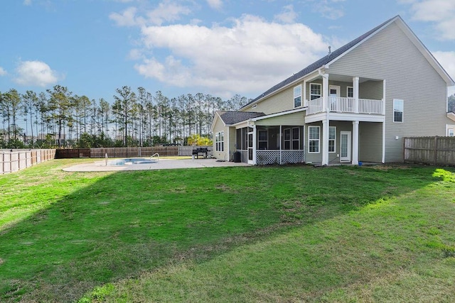 back of property featuring a patio, a sunroom, a lawn, and a fenced in pool