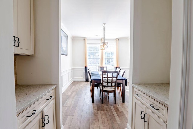 dining room featuring ornamental molding and light hardwood / wood-style floors