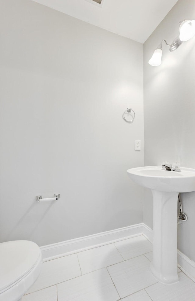 bathroom with toilet and tile patterned flooring