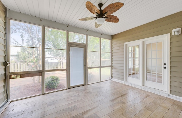 unfurnished sunroom featuring wooden ceiling, a healthy amount of sunlight, and ceiling fan