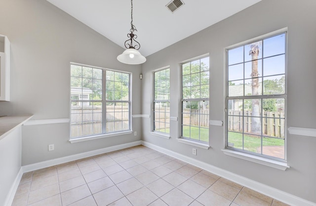 unfurnished dining area featuring a wealth of natural light, lofted ceiling, and light tile patterned flooring