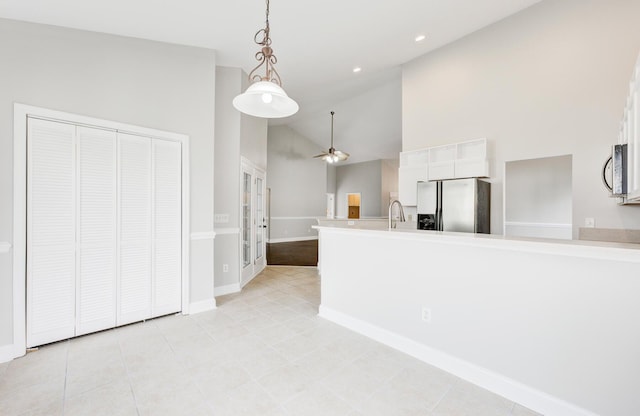 kitchen featuring stainless steel appliances, sink, pendant lighting, white cabinets, and high vaulted ceiling