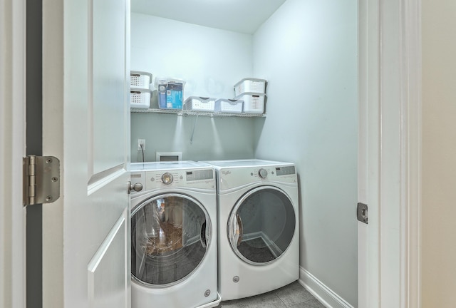 laundry area featuring light tile patterned floors and washing machine and clothes dryer