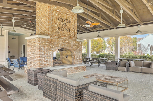 view of patio / terrace featuring a gazebo, an outdoor living space with a fireplace, and ceiling fan