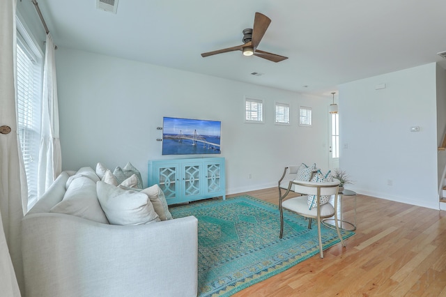 living room featuring hardwood / wood-style floors and ceiling fan