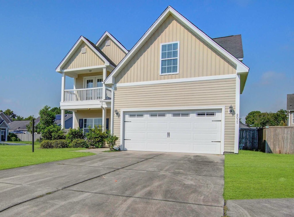 view of front of property with a garage, a front lawn, and a balcony