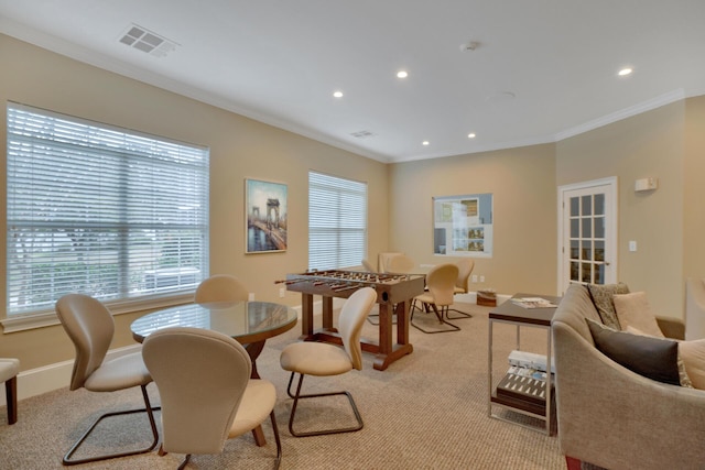 carpeted dining room with ornamental molding