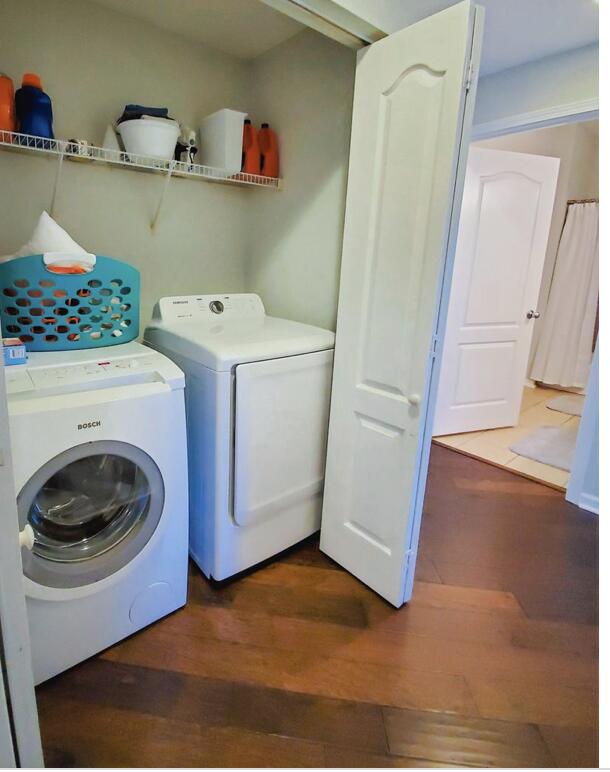 washroom with washer and clothes dryer and dark hardwood / wood-style flooring