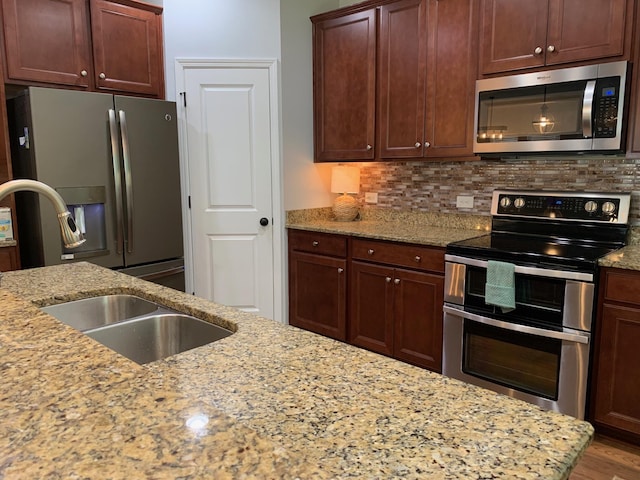 3808 Tupelo Branch Row, Mount Pleasant, SC 29429 - kitchen with appliances with stainless steel finishes, decorative backsplash, light stone countertops, and wood finished floors