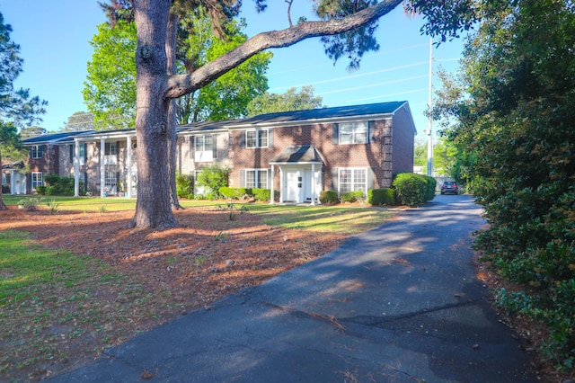 view of front of home featuring brick siding and driveway