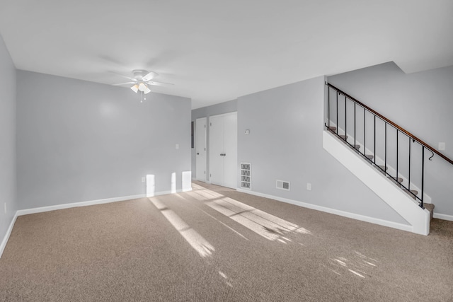 unfurnished living room featuring ceiling fan, carpet, baseboards, and stairs